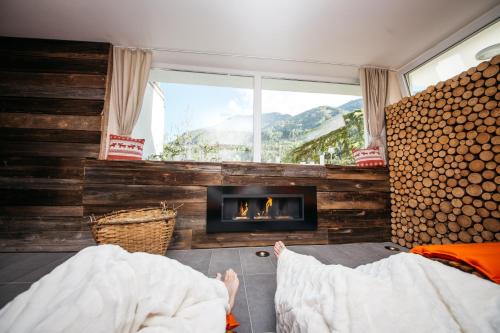 a person laying in bed in a room with a fireplace at Ferienhaus Melita in Bleiburg