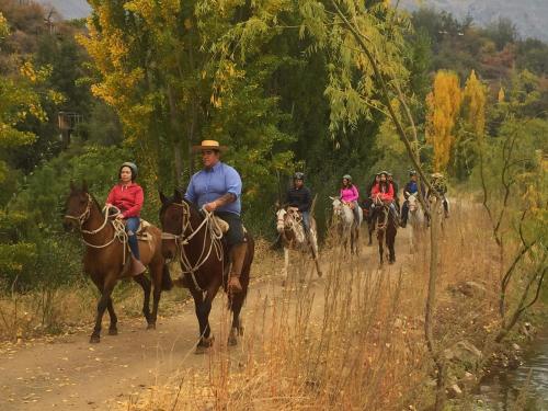 a group of people riding horses down a dirt road at San Francisco Lodge in Los Andes