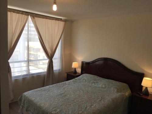 1 dormitorio con 1 cama y una ventana con 2 lámparas en Departamento Vergara en Santiago
