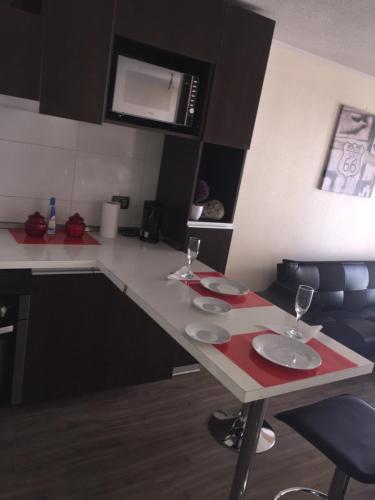 a kitchen with a table with wine glasses on it at Departamento Vergara in Santiago