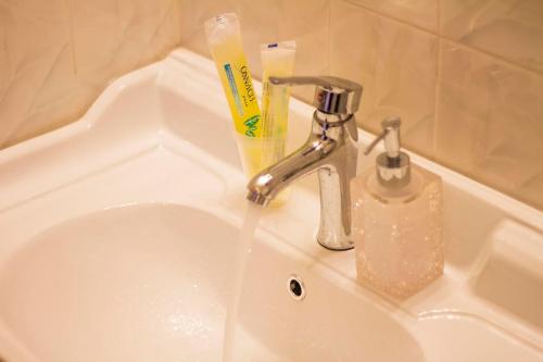 a sink with a toothbrush and a bottle of toothpaste at Phoenix Hotel Brooklyn Sunset Park in Brooklyn