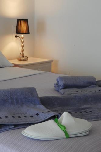 two beds with towels and a hat on them at Lino Apartments in Paradise Beach