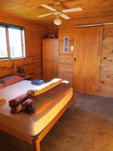 a bedroom with a bed in a wooden cabin at Cape Oasis Guesthouse in Bloubergstrand