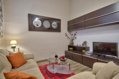 a living room with a couch and a tv at Valletta Apartments 19 in Valletta