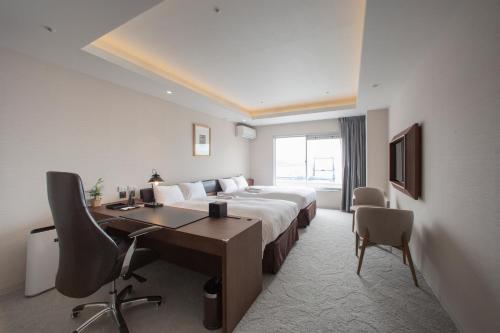 a hotel room with a bed and a desk and a computer at Clayton Bay Hotel in Kure