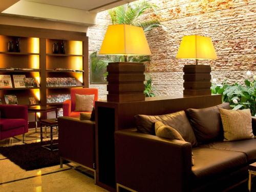 a living room with a couch and two lamps at TURIM Ibéria Hotel in Lisbon