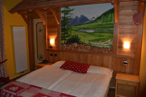 a bedroom with a bed with a painting on the wall at Hotel Cova in Pellizzano