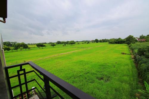 a view from a balcony of a green field at Nava Resort in Nakhon Nayok