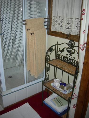 une douche avec une chaise et un rideau de douche dans l'établissement La Ferme Rose, à Cergy