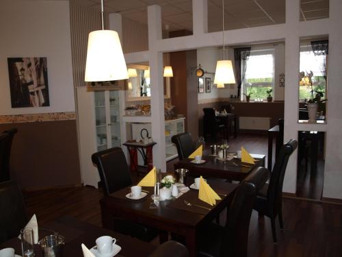 a dining room with tables and chairs in a restaurant at Hotel am Schützenberg in Gotha