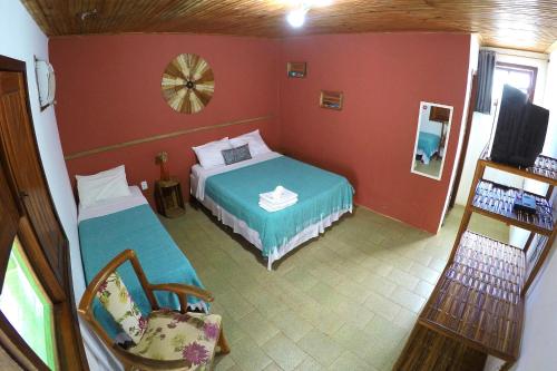 a room with two beds and a television in it at Pousada Tikuna in Itacaré