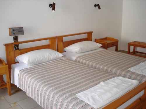 two beds sitting next to each other in a room at Popi Hotel Apartments in Agia Marina Nea Kydonias