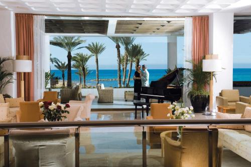 a hotel lobby with a piano and the beach at Constantinou Bros Pioneer Beach Hotel in Paphos