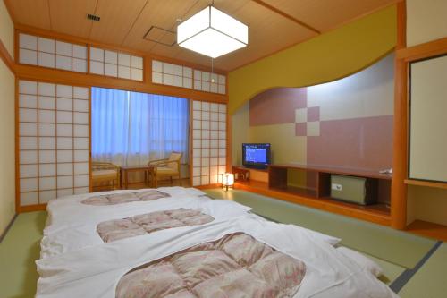 una camera con letto e TV di Hill Hotel Sunpia Iga a Iga