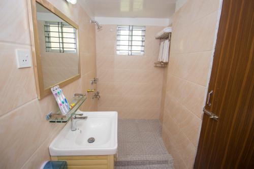 a bathroom with a sink and a mirror at Hotel Progati Inn Ltd. in Dhaka