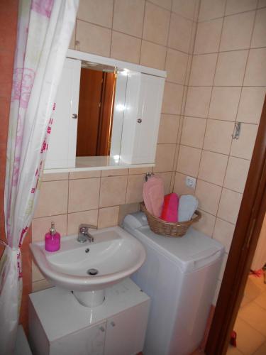 a bathroom with a sink and a toilet and a mirror at Evgenia Maisonette in Ierissos