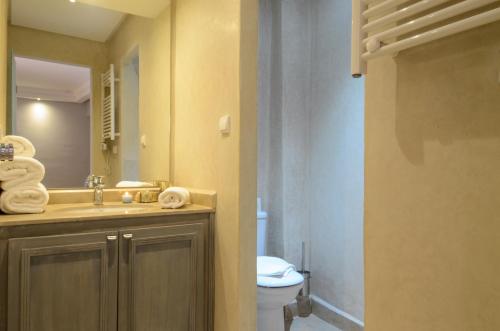 un bagno con lavandino, WC e specchio di Riad Ayni a Marrakech