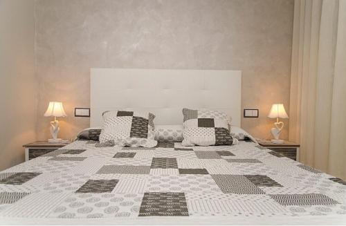 Hostal Don Rodrigo في سمورة: غرفة نوم كبيرة مع سرير كبير مع مصباحين