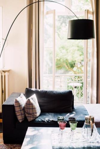 a living room with a couch and a table with wine glasses at Castel Jolly in Rennes