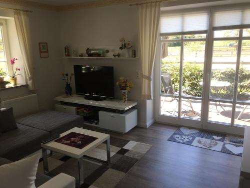 a living room with a couch and a tv at Ferienwohnung am Gibbach in Kirchlinteln