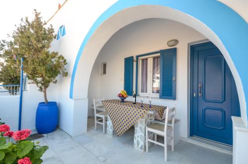 a blue door on a house with a table and chairs at Surfer Studios in Mikri Vigla