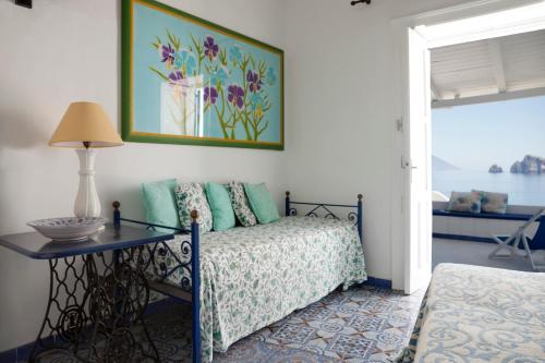 a bedroom with a bed and a table with a lamp at Casa Prete in Panarea