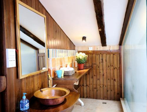 a bathroom with a sink and a wooden wall at Shangri-La mid - mountain homestay in Shangri-La