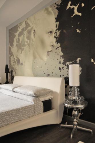 a bedroom with a painting of a woman on a wall at B&B Albornoz in Urbino
