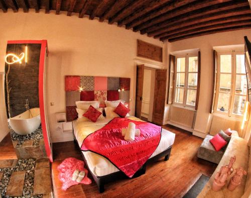 a bedroom with a large bed and a tub in it at le XVI de la Rose in Lyon