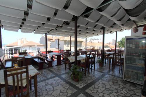 ein Restaurant mit Tischen und Stühlen unter einem Dach in der Unterkunft Family Hotel Verona in Sozopol