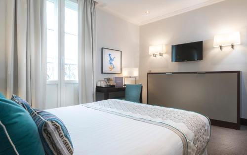 a hotel room with a bed and a desk at Montfleuri in Paris