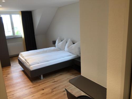 a small bed in a room with a window at Gasthof National in Langendorf