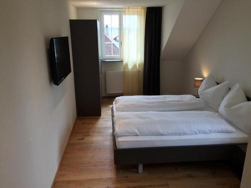 a small bedroom with a bed and a window at Gasthof National in Langendorf