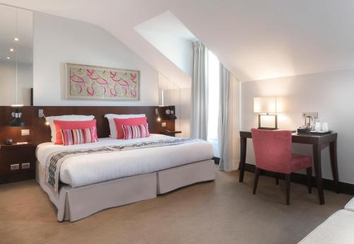 a bedroom with a bed and a desk and a chair at Montfleuri in Paris
