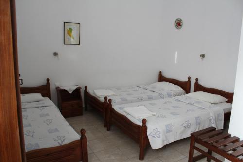 a group of four beds in a room at Electra in Líndos
