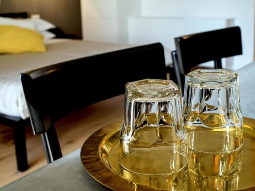 two glasses of yellow wine on a table at Talè Restaurant & Suite in Piedimonte Etneo