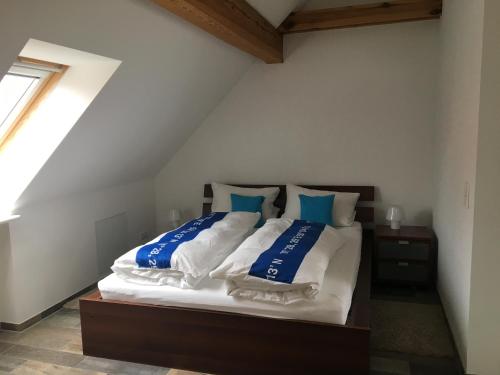 Schlafzimmer mit einem Bett mit blauen und weißen Kissen in der Unterkunft Studio Templin in Templin