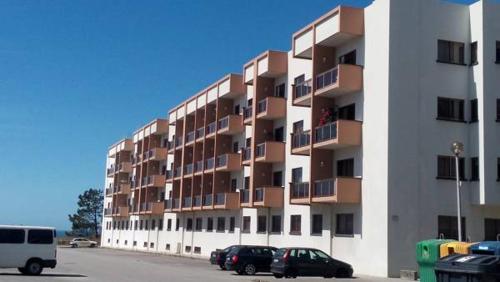 a large apartment building with cars parked in a parking lot at Apartamento T3 Amorosa in Viana do Castelo