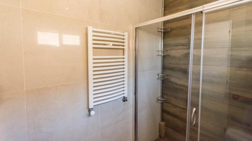 baño con ducha y puerta de cristal en Casa hermosa vista en Villa Carlos Paz