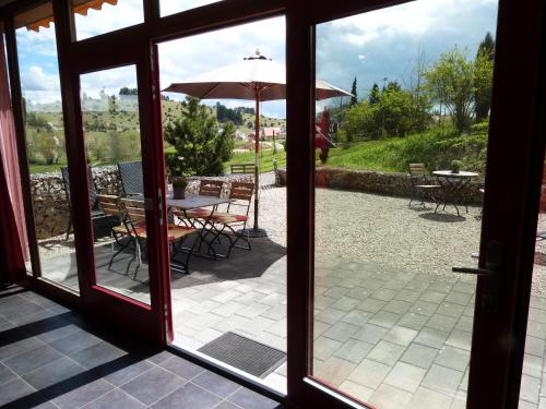 an open door to a patio with a table and an umbrella at Alb Lodge in Gomadingen