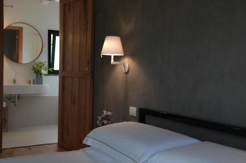 a bedroom with a bed and a lamp on a wall at Talè Restaurant & Suite in Piedimonte Etneo