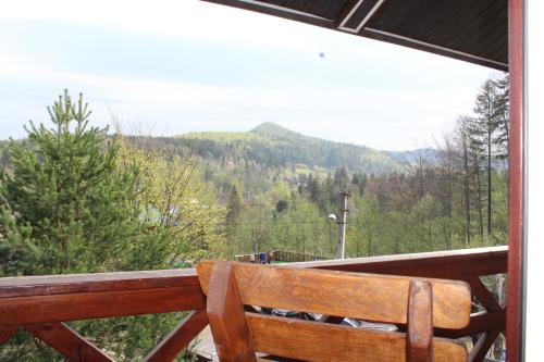a wooden bench on a balcony with a view of a mountain at Vatra Hotel in Yaremche