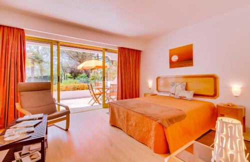 a hotel room with a bed and a chair at Apartamento Victoria in Vilamoura