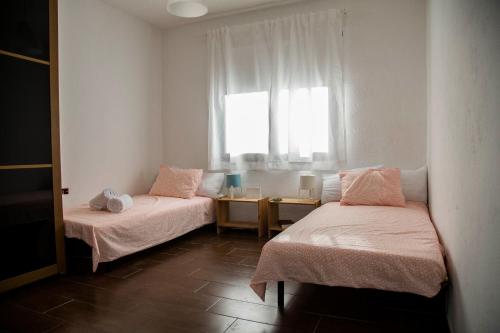 due letti in una stanza con finestra di Casa Candela a Tinajo