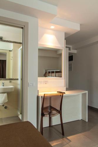 a room with a table and a chair and a bathroom at Hotel Augustus- Davanti a noi c'è solo il mare in Misano Adriatico
