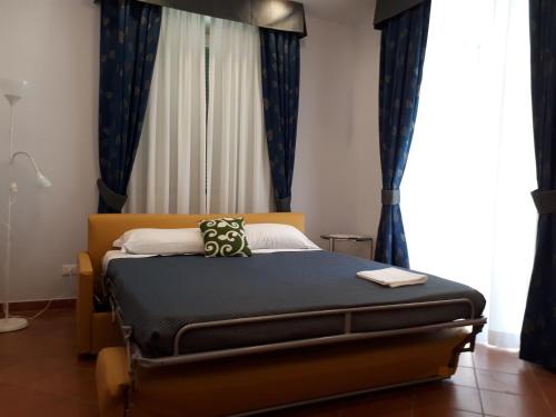 a bed in a bedroom with blue curtains at Clodio Rooms in Rome
