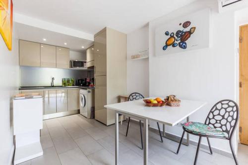 - une cuisine avec une table et des chaises blanches dans l'établissement Maison de Vacances - Casa Mezanaccia avec Terrasse fleurie meublé tourisme 3 étoiles, à Santa-Lucia-di-Tallano