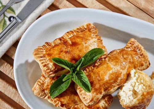 a white plate with a piece of pie with a green leaf at Paul Marie in Hersonissos
