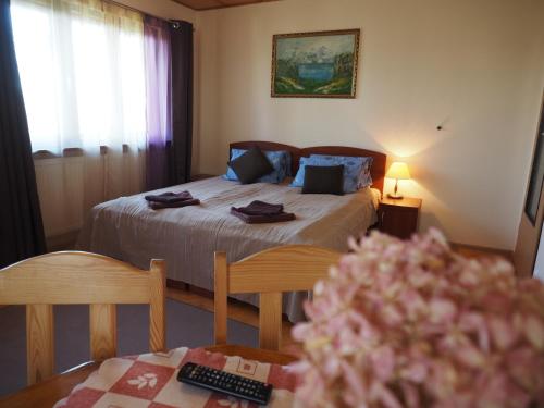 ウストカにあるDom wakacyjny Sztoremのベッドルーム1室(ベッド1台、花のテーブル付)
