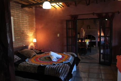 a bedroom with a bed and a brick wall at Raíces Ongamira in Ongamira